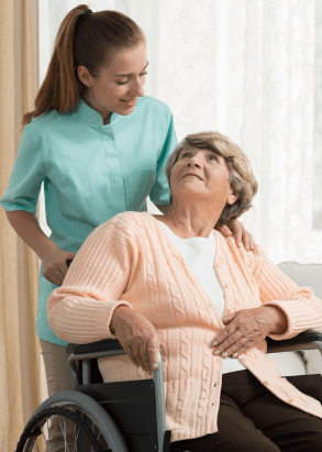 Do you need help for you or a loved one? Professional caregiver assisting a senior in a wheelchair with compassionate in-home care from Loving Hands Homecare Agency in Eaton Rapids, Michigan.