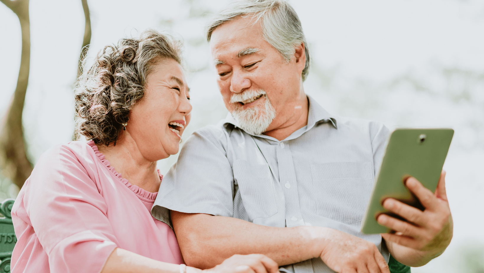 Smiling older couple using a tablet together at home in Eaton Rapids, Michigan.