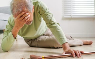 Older adult on the floor after a fall reaching for a walking cane at home.