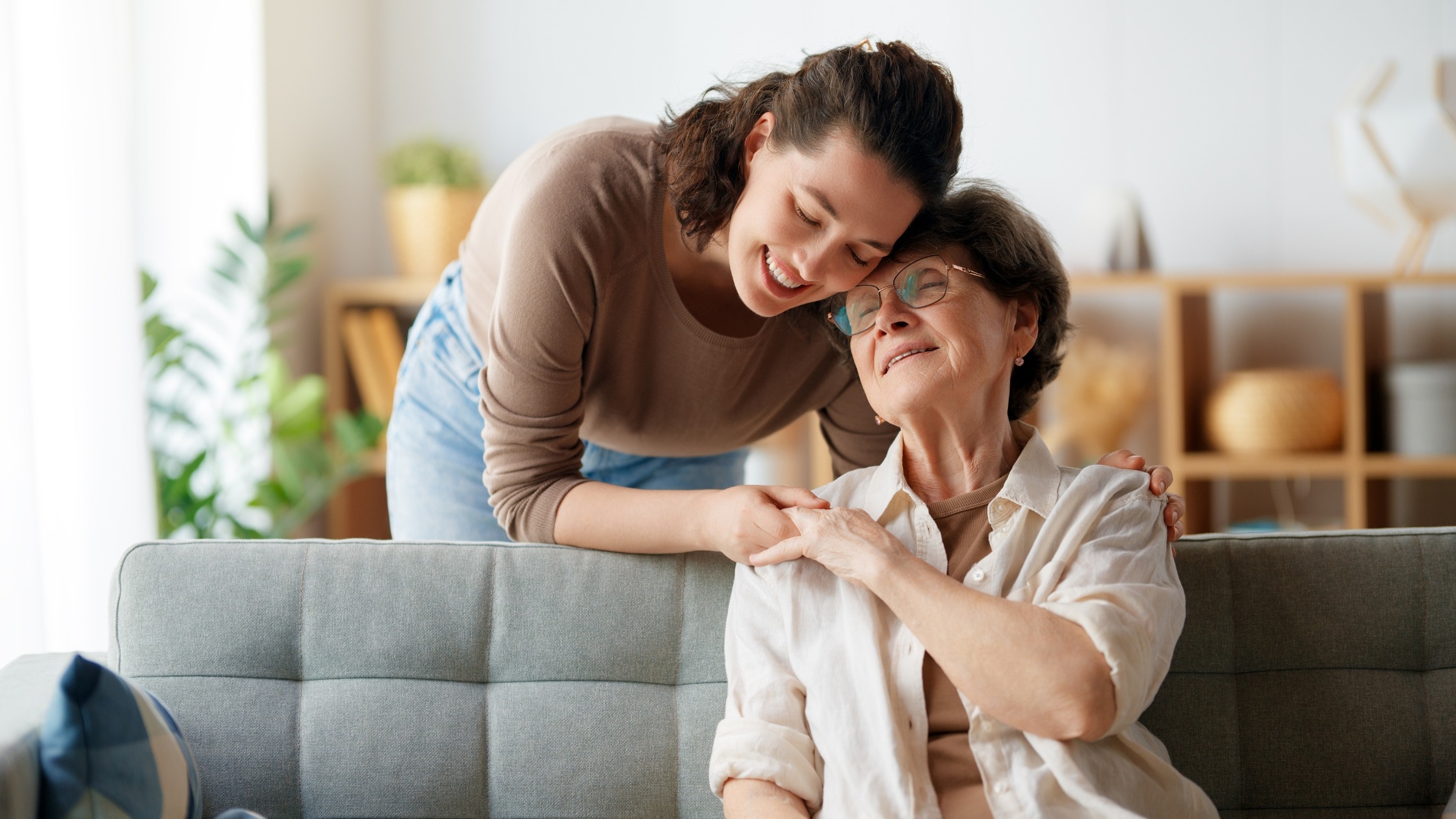Family caregiver comforting and supporting an older adult at home.