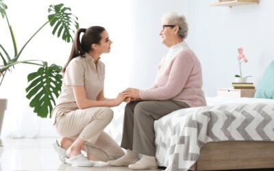 Caregiver talking with an older adult during an in-home care visit.