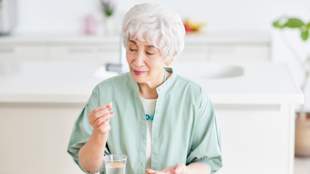 Senior taking medication at home with support from medication reminders in Eaton Rapids, MI.